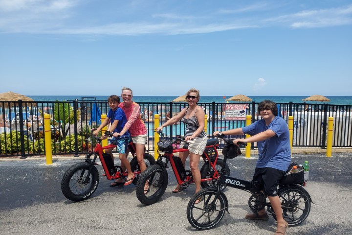 a group of people riding ebikes on the road in front of a pool