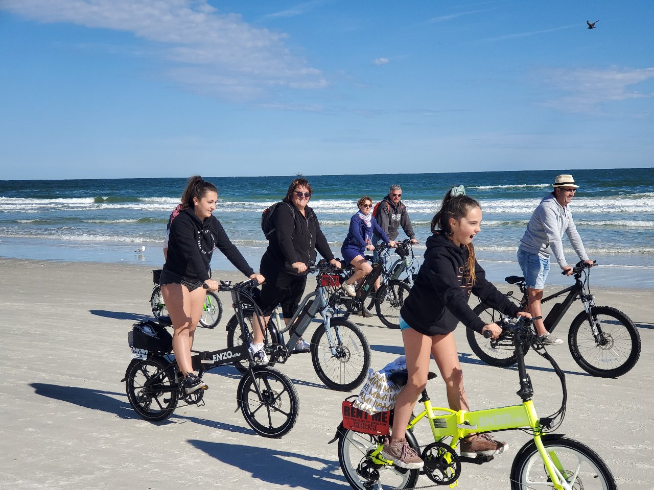 a group of people riding ebikes on the beach