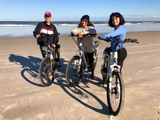 a group of people riding on the back of a bicycle